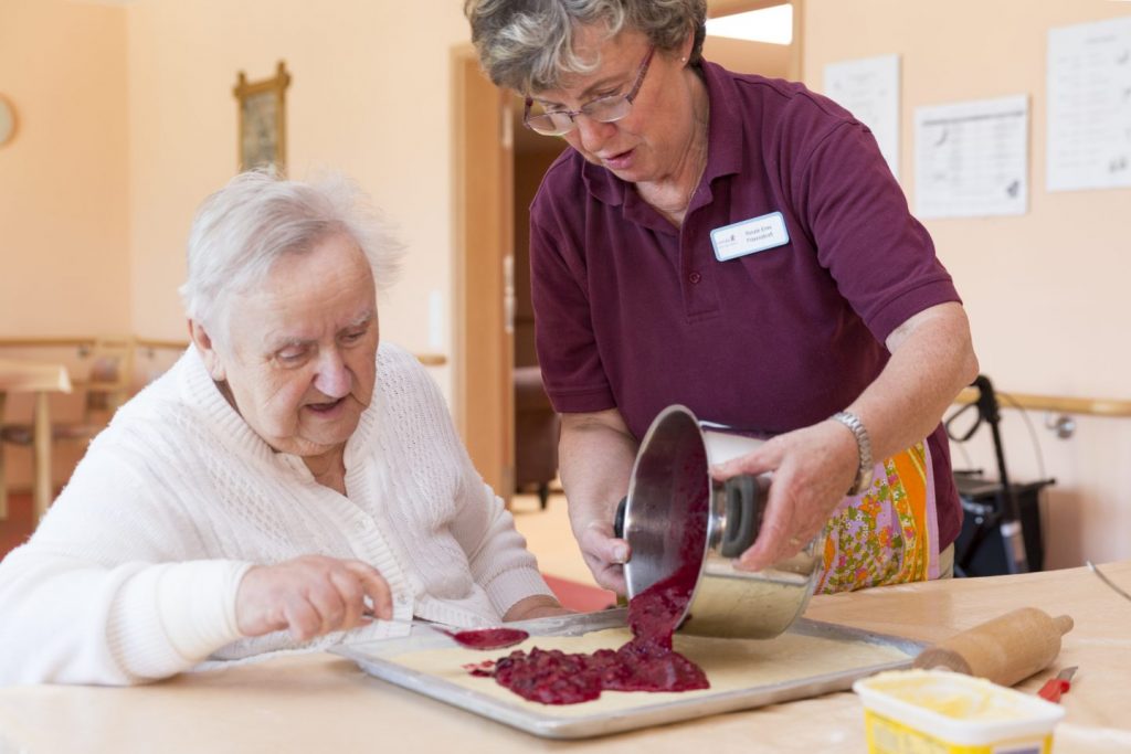 Mitarbeiter backt mit Bewohner einen Kuchen